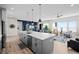 Kitchen with large island, stainless steel appliances, and gray cabinetry flows into a comfortable living space at 11136 Sweet Cicely Dr, Parker, CO 80134