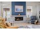 Cozy living room with a stone fireplace, adjacent to a modern kitchen with stainless steel appliances and ample natural light at 11136 Sweet Cicely Dr, Parker, CO 80134
