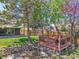 Elevated backyard deck with seating overlooks a lush yard with mature trees and a rock-lined dry creek at 8468 Chase Dr, Arvada, CO 80003