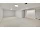 Spacious basement with white carpet and walls, offering a versatile area for recreation or additional living space at 8468 Chase Dr, Arvada, CO 80003