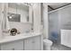 Bright bathroom featuring a white vanity, mirrored cabinet, and enclosed shower with frosted glass door at 8468 Chase Dr, Arvada, CO 80003