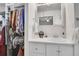 Clean bathroom showcases a vanity with ample storage space and a view into the walk-in closet at 8468 Chase Dr, Arvada, CO 80003
