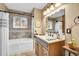 Relaxing bathroom featuring neutral tiling, a tub with shower, and wood vanity, exuding elegance at 8468 Chase Dr, Arvada, CO 80003