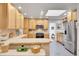 Bright kitchen with light wood cabinets, tile countertops, stainless steel appliances, and a skylight at 8468 Chase Dr, Arvada, CO 80003
