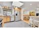 Bright kitchen with stainless steel appliances, skylight, light wood cabinets, and a breakfast bar at 8468 Chase Dr, Arvada, CO 80003