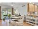 Dining area adjacent to kitchen with light wood floors and access to a patio via sliding glass doors at 8468 Chase Dr, Arvada, CO 80003