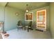 Inviting covered front porch with charming Adirondack chairs, lantern, and a decorative wood and glass front door at 8468 Chase Dr, Arvada, CO 80003