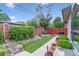 Landscaped backyard featuring an artificial lawn, brick borders and a stone garden at 4274 E Dickenson Pl, Denver, CO 80222