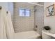 Cozy bathroom with patterned tile, a window, and a shower-tub combination at 5563 Newland Way, Arvada, CO 80002