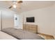 Bright bedroom featuring hardwood floors, a ceiling fan, and a dresser with a wall-mounted television at 5563 Newland Way, Arvada, CO 80002