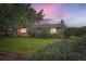 Brick home on a large lot with green grass and lush bushes at 5563 Newland Way, Arvada, CO 80002