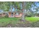 Brick ranch home with green lawn and mature shade tree at 5563 Newland Way, Arvada, CO 80002