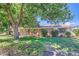 Brick home with a well-manicured lawn and mature bushes at 5563 Newland Way, Arvada, CO 80002