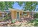 Charming brick home featuring a covered front porch and mature trees at 5563 Newland Way, Arvada, CO 80002