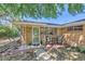 Charming brick home featuring a covered front porch with a cozy seating area at 5563 Newland Way, Arvada, CO 80002