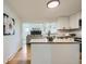 Well-lit kitchen with stainless appliances, subway tile backsplash, and view into Gathering room at 5563 Newland Way, Arvada, CO 80002