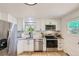 Modern kitchen featuring stainless steel appliances, white cabinets, and hardwood floors at 5563 Newland Way, Arvada, CO 80002