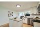 Updated kitchen with stainless steel appliances, white cabinetry, and open sight lines to living space at 5563 Newland Way, Arvada, CO 80002