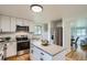 Modern kitchen with stainless steel appliances, white cabinetry, and functional island at 5563 Newland Way, Arvada, CO 80002