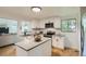 Modern kitchen with white cabinets, stainless steel appliances, and a center island at 5563 Newland Way, Arvada, CO 80002