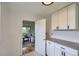 Bright kitchenette with white cabinets, gray countertops, and an open doorway to the living room at 5563 Newland Way, Arvada, CO 80002