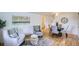 Cozy living room features hardwood floors, comfortable seating and seamless flow into dining area at 5563 Newland Way, Arvada, CO 80002