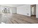 Open-concept living room with wood-look floors and access to the outdoor patio through sliding glass doors at 4598 Boone Cir, Brighton, CO 80601