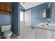 Cozy bathroom features blue walls, white tile, and a vanity with double sinks providing ample space and storage at 8847 Cloverleaf Cir, Parker, CO 80134