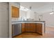 This kitchen has light countertops, wood cabinets, stainless steel dishwasher, and flows to a living/dining area at 8847 Cloverleaf Cir, Parker, CO 80134