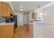 Functional kitchen with wooden cabinetry, a breakfast bar, and black appliances, offering a practical space for cooking at 8847 Cloverleaf Cir, Parker, CO 80134