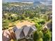 Stunning aerial view of a luxury home surrounded by trees and overlooking a beautiful mountain range and neighborhood at 1975 Wild Star Way, Castle Rock, CO 80104