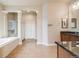 Bathroom with tile flooring, dual sinks, walk-in shower, bathtub, and white trim at 1975 Wild Star Way, Castle Rock, CO 80104
