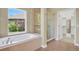 Luxurious bathroom with a soaking tub, glass-enclosed shower, and large window at 1975 Wild Star Way, Castle Rock, CO 80104