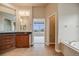 Bright bathroom features double vanity, tile floor, soaking tub, and an entrance to the bedroom at 1975 Wild Star Way, Castle Rock, CO 80104