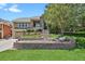 Beautiful two-story home featuring a stone facade, manicured lawn, and tiered landscaping at 1975 Wild Star Way, Castle Rock, CO 80104