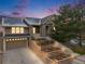 Inviting two-story home featuring a stone facade, attached garage, and landscaped tiered front yard at 1975 Wild Star Way, Castle Rock, CO 80104