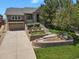 A beautiful two-story home with a well-manicured lawn, retaining walls, and a charming garden at 1975 Wild Star Way, Castle Rock, CO 80104