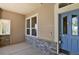 Charming front porch showcasing stone accents, beige siding, and a bright blue front door at 1975 Wild Star Way, Castle Rock, CO 80104