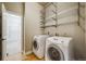 Bright laundry room featuring a washer, dryer, wire racks for storage, and tile floors at 1975 Wild Star Way, Castle Rock, CO 80104