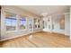 Spacious living room with hardwood floors and large windows leading to an outdoor balcony at 1975 Wild Star Way, Castle Rock, CO 80104