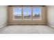 Empty bedroom with carpet, windows, light-colored walls and a view of fencing and trees at 1975 Wild Star Way, Castle Rock, CO 80104