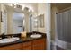 Well-lit bathroom featuring double sinks, a granite countertop, large mirror, and a tub with a shower at 1320 S Monaco St Pkwy # 3, Denver, CO 80224