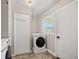 Functional laundry room with washer, dryer, and storage, featuring a window at 1325 Dayton St, Aurora, CO 80010