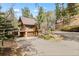 Exterior of a multi-story home with a driveway surrounded by lush trees, creating a private setting at 13609 Elsie Rd, Conifer, CO 80433