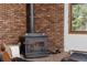 Close-up of a wood-burning stove and brick accent wall, adding warmth to the living area at 13609 Elsie Rd, Conifer, CO 80433