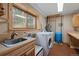 Laundry room featuring a sink, countertops, cabinets, a window, and laundry appliances, providing a functional space at 13609 Elsie Rd, Conifer, CO 80433