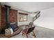 Living area featuring a brick fireplace, wood-framed windows, and comfortable seating at 13609 Elsie Rd, Conifer, CO 80433