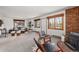 Open living space with brick accents, comfortable seating, and scenic views from multiple windows at 13609 Elsie Rd, Conifer, CO 80433