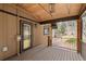 Inviting covered porch featuring wood flooring, rustic beams, and an exterior wall sconce at 13609 Elsie Rd, Conifer, CO 80433