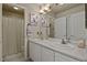 Bright bathroom featuring double vanity with white cabinets, tub/shower combo with shower curtain, and neutral wall color at 11839 Saddleback Ct, Parker, CO 80138